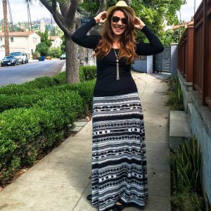A woman wearing a black and white maxi skirt and black top.