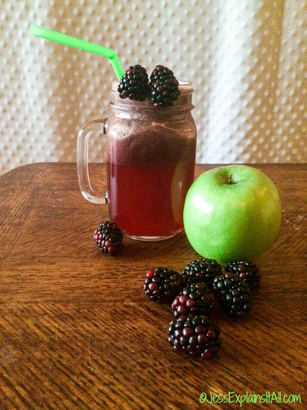 Mason jar mug with autumn fresh juice and an apple and blackberries