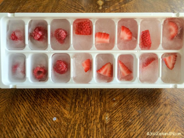 A tray of raspberry and strawberry with water