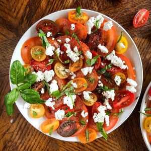 Tomato mozzarella salad plate garnished with basil and balsamic