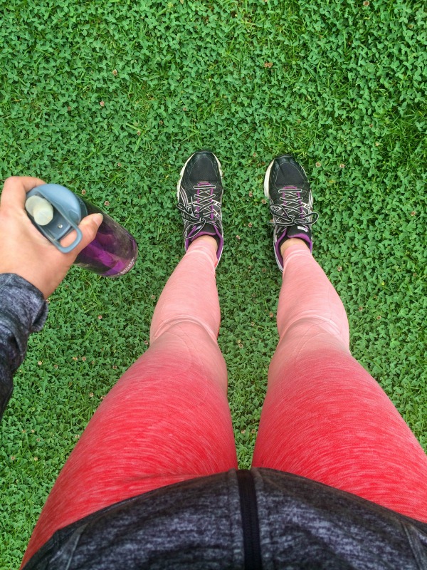 A photo of pink leggings, tennis shoes and a purple water bottle from above.