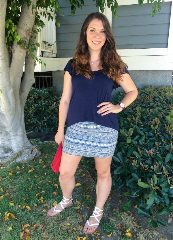 A brunette girl standing in front of a house.