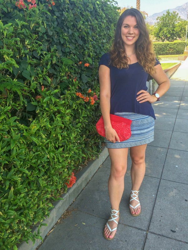 Brunette standing outside in a neighborhood wearing blue.