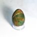 A green and red bloodstone egg on a glass stand.