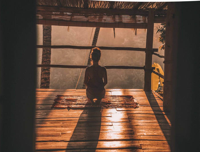 a woman meditating in the morning at sunrise